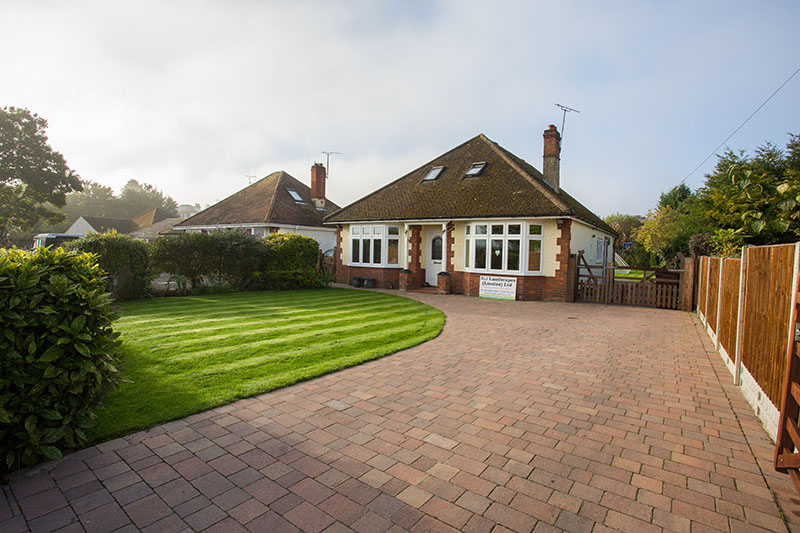 mixed brick driveway next to artificial grass