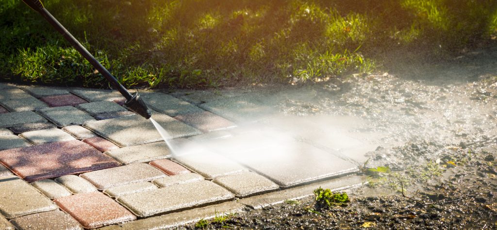 dirty block pavement cleaning with high pressure washer.